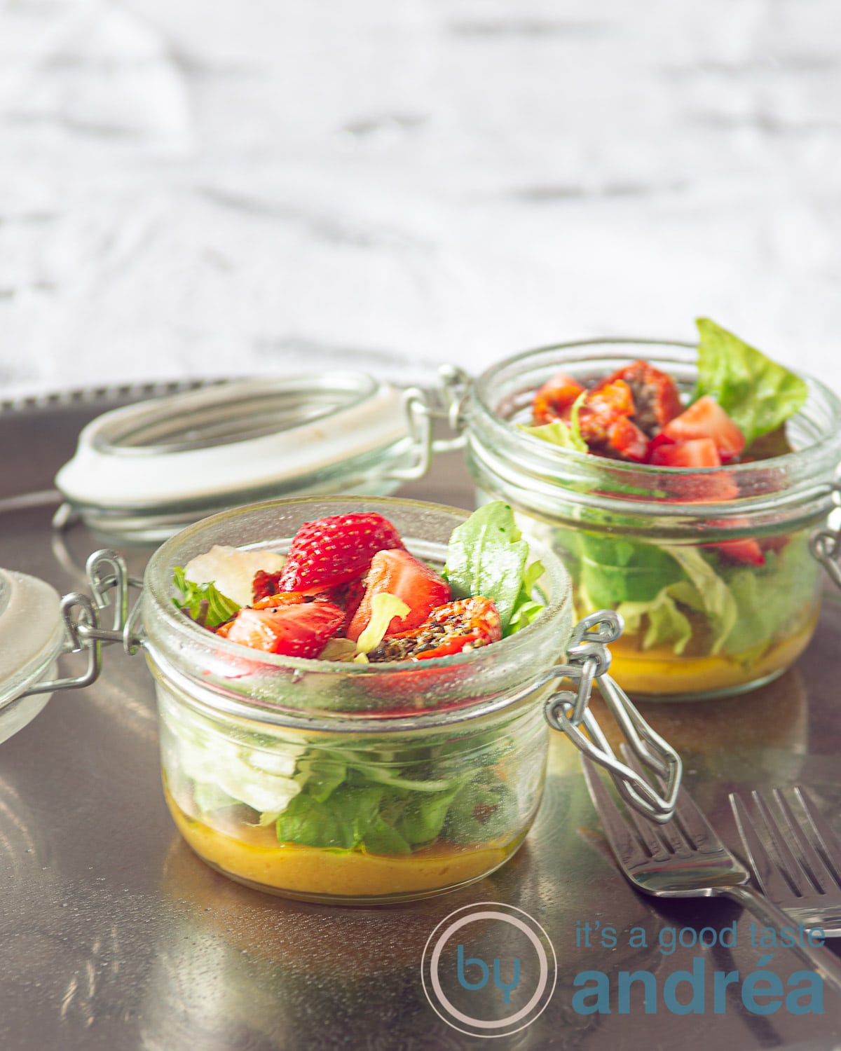 twee potten met een salade met zongedroogde tomaten, aardbeien en een honing mosterd dressing
