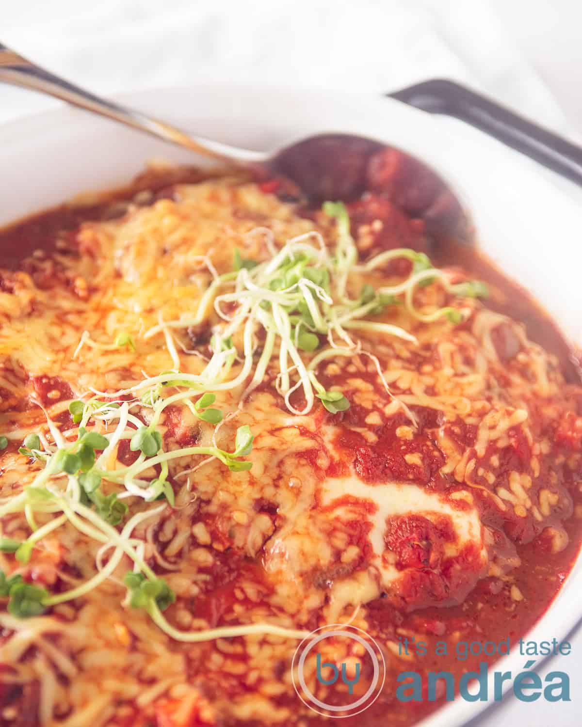 een ovenschaal met schnitzel en veel groenten. Een heerlijke kaas gratin en wat cress erop.