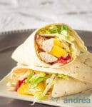 twee wraps gevuld met kip, mango, tomaat en sla op een zilveren bord