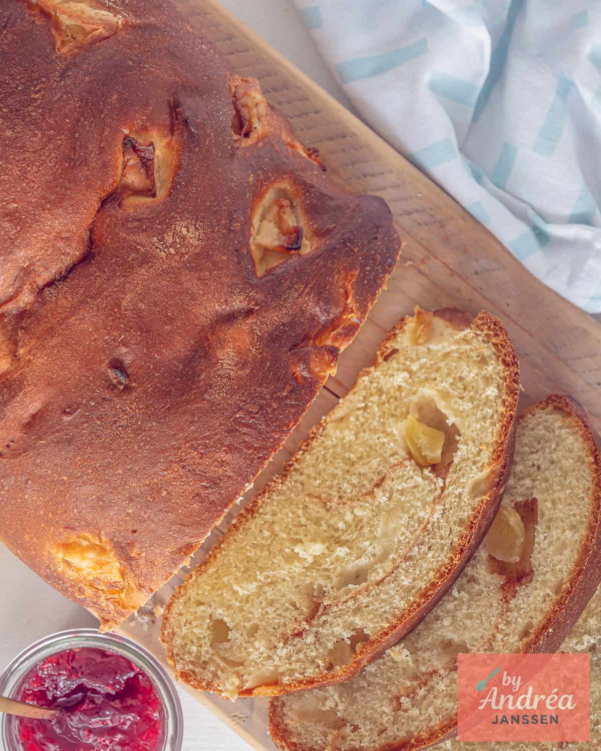Een foto van bovenaf van een appelbrood met stukjes appel, twee plakken erafgesneden.