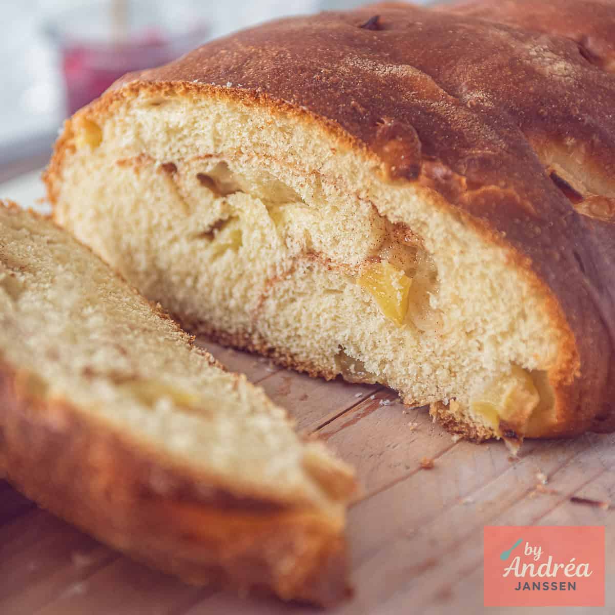 Een vierkante foto met een appelbrood waar een plak is afgesneden en je de binnenkant kunt zien