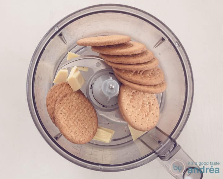 Een kom van een foodprocessor met koekjes en witte chocola.