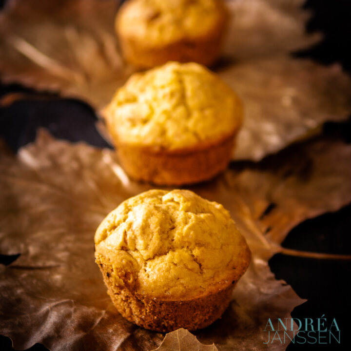 3 mais muffins op een rij op gouden blaadjes