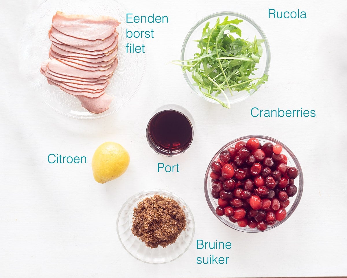Ingrediënten Amuse van eendenborstfilet, cranberry en rucola op een witte ondergrond met tekst beschrijving