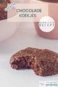 Een koekje met chocolade waaruit een hap is genomen. Bovenin een tekst: chocolade koekjes, bakken, makkelijk recept