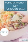 Een deel van een roze kom met pasta, gerookte zalm, Parmezaanse kaas, crème fraîche en zongedroogde tomaatjes. Een tekst bovenin: spaghetti met gerookte zalm, makkelijk recept.