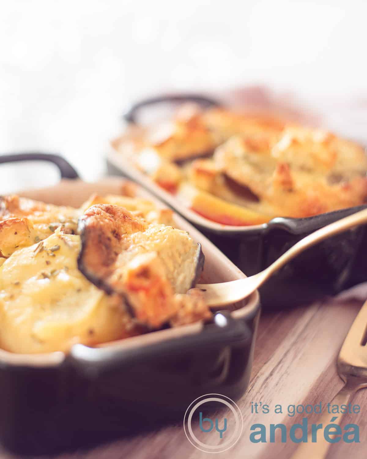 Twee een persoons Griekse moussaka ovenschotel bakjes en een blauwe theedoek