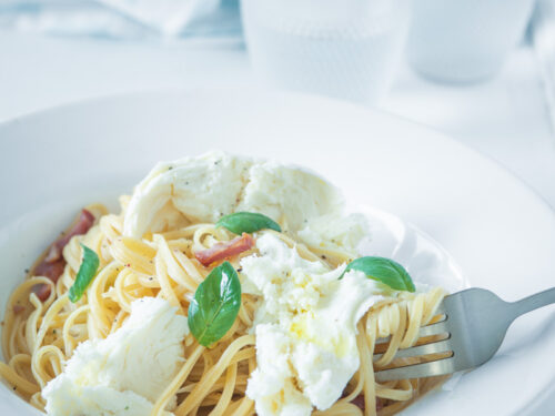 een wit bord met miso spaghetti, spekjes en mozzarella