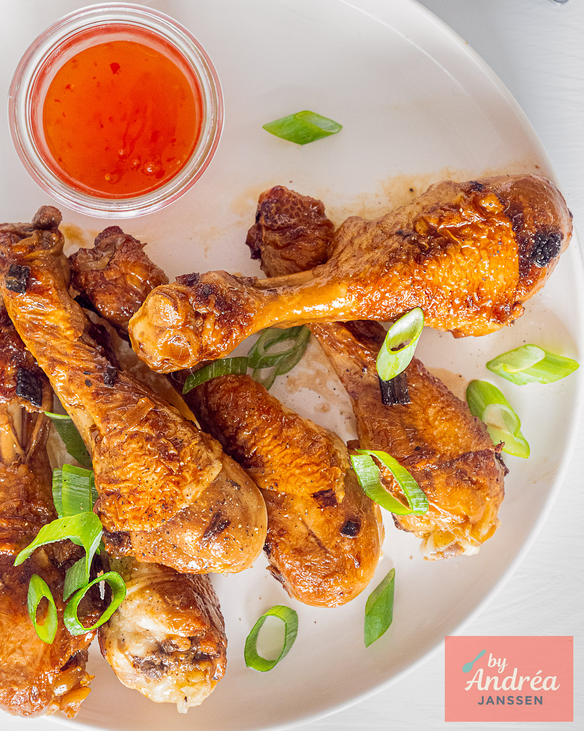 Kipdrumsticks met ketjapsaus en bosui, van bovenaf gefotografeerd