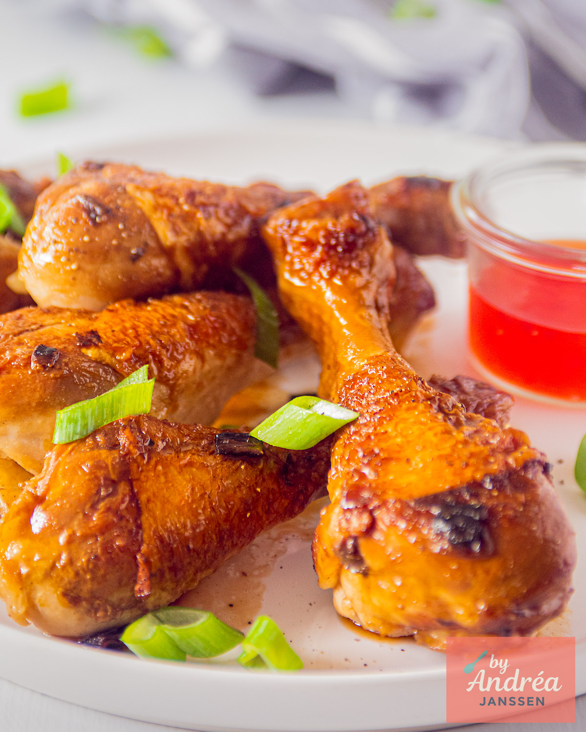 Kipdrumsticks met glanzende ketjapsaus, bosui en een schaaltje chilisaus