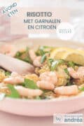 Een roze koekenpan gevuld met risotto rijst, garnalen, rucola en citroen. Een textoverlay bovenin: risotto met garnalen en citroen, avondeten, makkelijk recept.