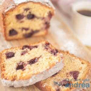 Een vierkante foto van een cake met blauwe bessen en een kopje koffie