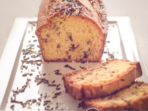 Hagelslag cake op een wit bord met hageslag eromheen. Een beige achtergrond.