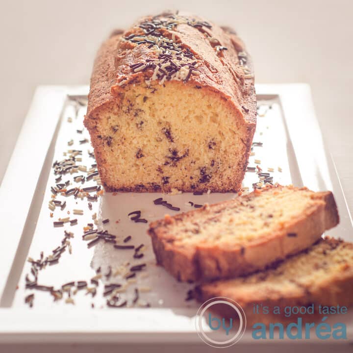 Hagelslag cake op een wit bord met hageslag eromheen. Een beige achtergrond.