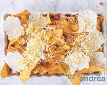 Een ovenschaal met nachos, tortilla spookjes en geraspte kaas