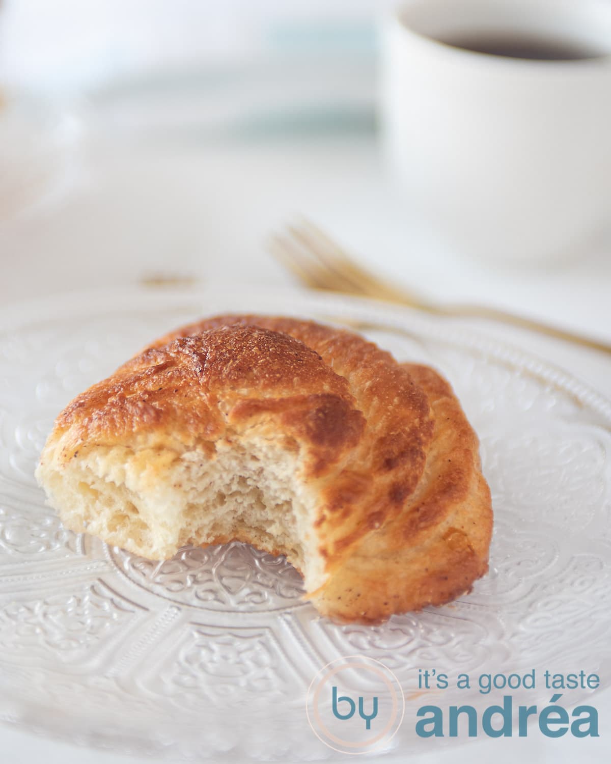 A plate with a bolus from which a. bite is bitten. The airy structure is visible. In the background a cup and a fork