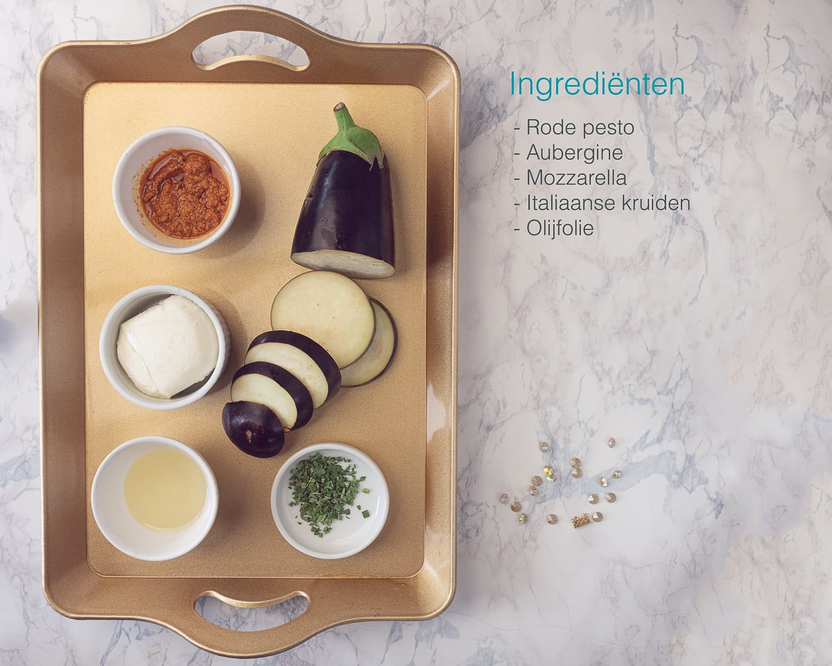Ingrediënten voor aubergine met mozzarella op een gouden dienblad. Een tekstbeschrijving ernaast