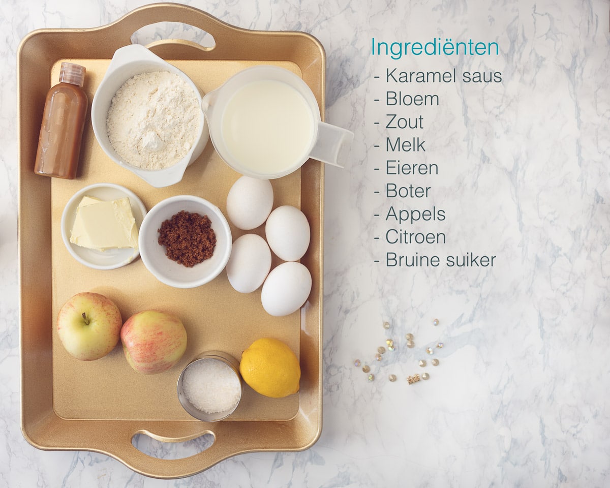 Ingrediënten gourmet dessert crêpes met appels op een gouden dienblad dat op een gemarmerde achtergrond staat met een beschrijving in tekst van de ingrediënten