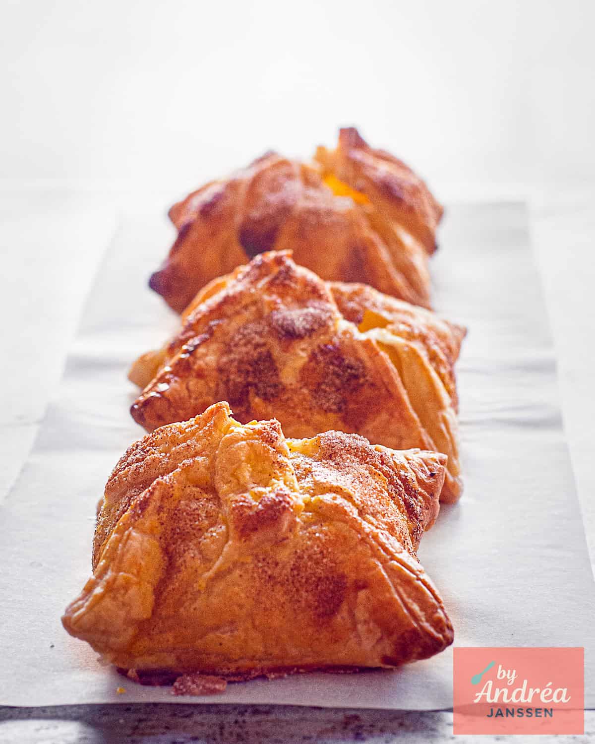 Drie gebakken bolle appelbuikjes op een rij achter elkaar.