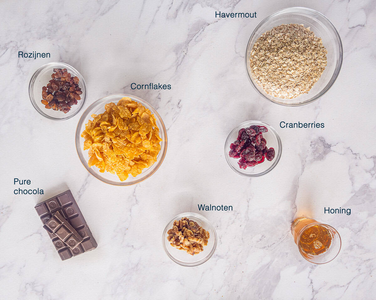 Ingredienten Chocolade muesli repen op een wit marmeren ondergrond met tekstbeschrijving