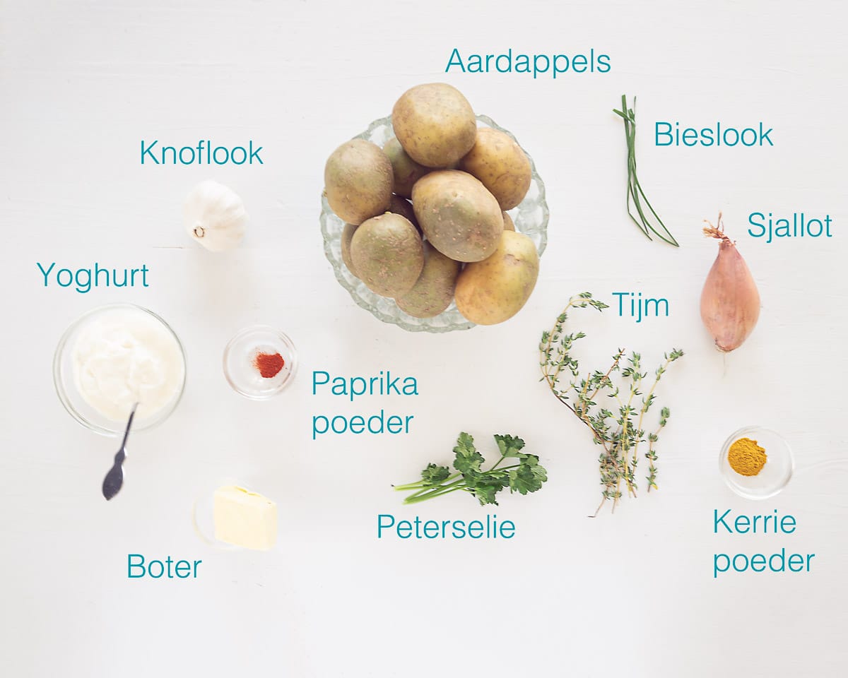 Ingrediënten gekruide gebakken aardappelen met yoghurt knoflooksaus op een witte ondergrond met tekst beschrijiving van de ingrediënten