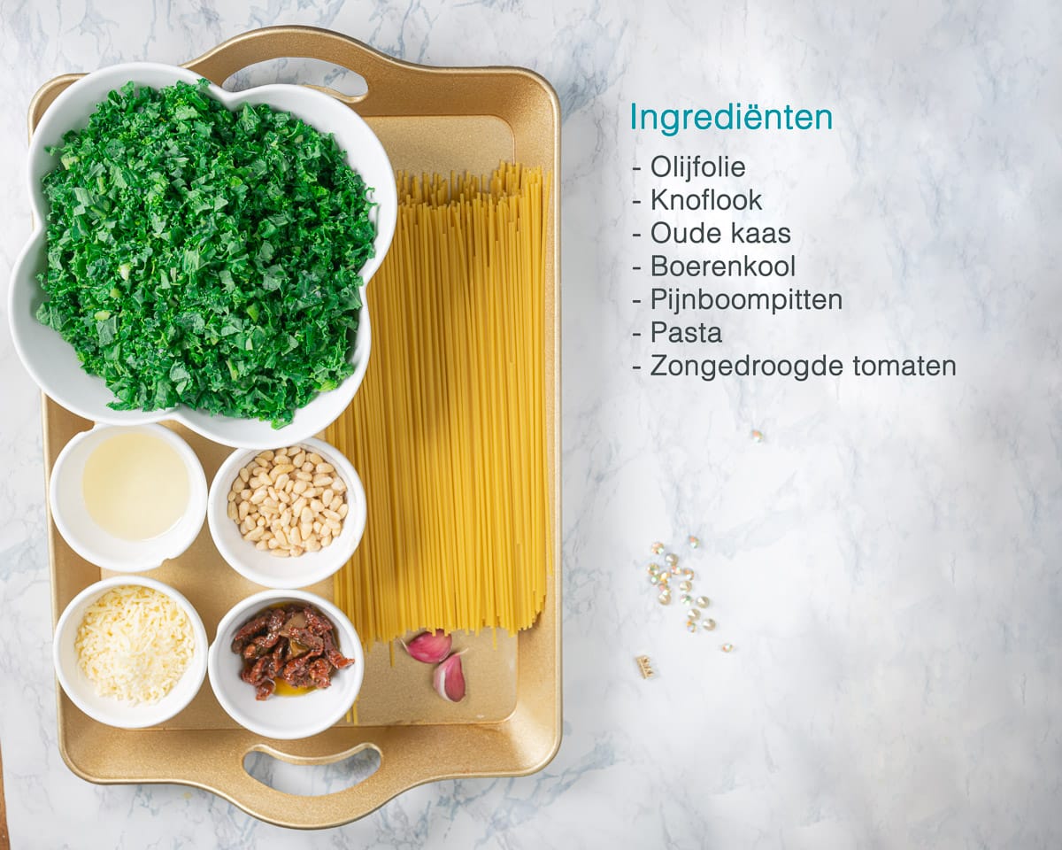 Ingrediënten Spaghetti met Boerenkoolpesto aan de linkerkant op een gouden dienblad. Aan de rechterzijde een tekstopsomming van de ingrediënten.