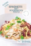 Een deel van een diep wit bord gevuld met spaghetti, boerenkoolpesto, zongedroogde tomaten en geraspte kaas. Bovenin een tekstoverlay: spaghetti met boerenkoolpesto, avondeten, makkelijk recept, pasta