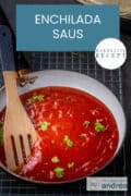 Een koekenpan gevuld met enchiladasaus met een houten spatel. Een tekst: makkelijk recept, enchilada saus