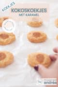 Een aantal kokoskoekjes in twee rijen, gevuld met karamel en zeezout. Een hand pakt een koekje onderin. Een tekst overlay kokoskoekjes met zeezout, koekjes, makkelijk recept, zoet bakken