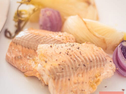 Een vierkant foto met Gepocheerde Zalm met Venkel en Sinaasappel op een wit bord