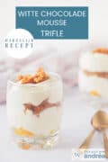 Twee glaasjes schuin achterelkaar met een trifle van witte chocolademousse, abrikozenjam en wortelcake. Een tekst: makkelijk recept, witte chocolademousse trifle