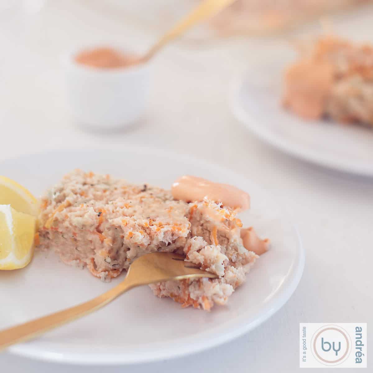 Een vierkante foto met twee bordjes met een plakje visterrine met kabeljauw en zalm. Whiskysaus in de achtergrond