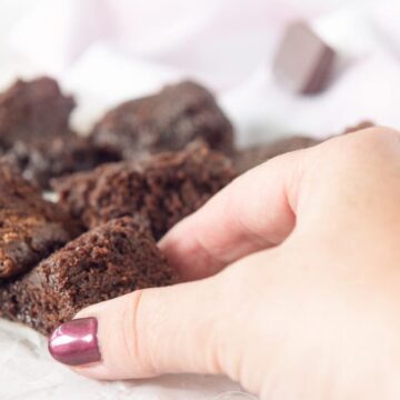 Een hand die een blokje brownie pakt