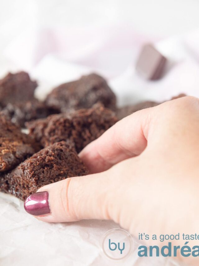 Een hand die een blokje brownie pakt