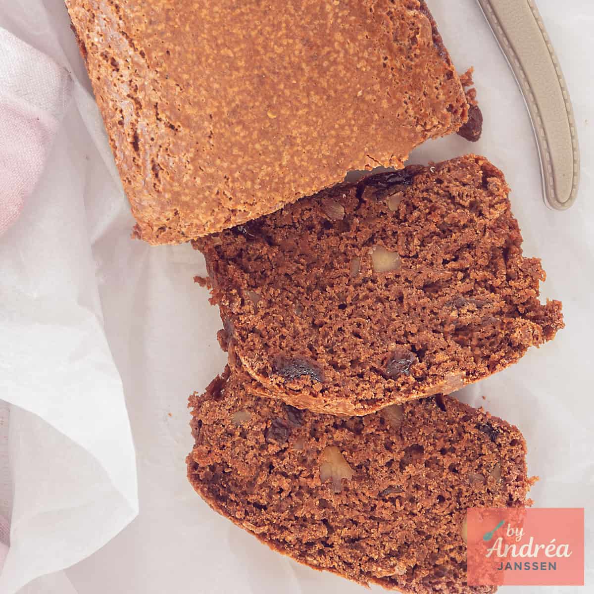 Een vierkante foto van bovenaf van een kruidkoek met krenten en walnoten