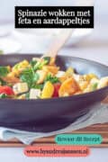 Een deel van een wok met aardappeltjes, spinazie, feta en tomaatjes, geroerbakt. Een tekst: spinazie wokken met feta en aardappeltjes