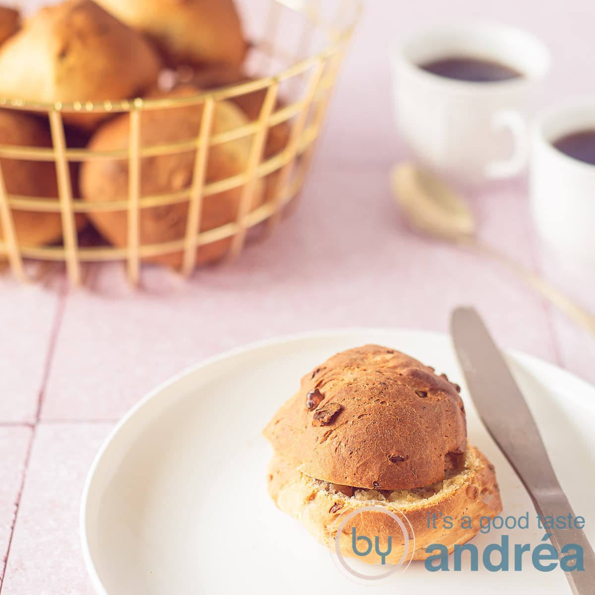 Een bord met een walnootbroodje met sinaasappelbroodjes met walnoten in de achtergrond in een mand.