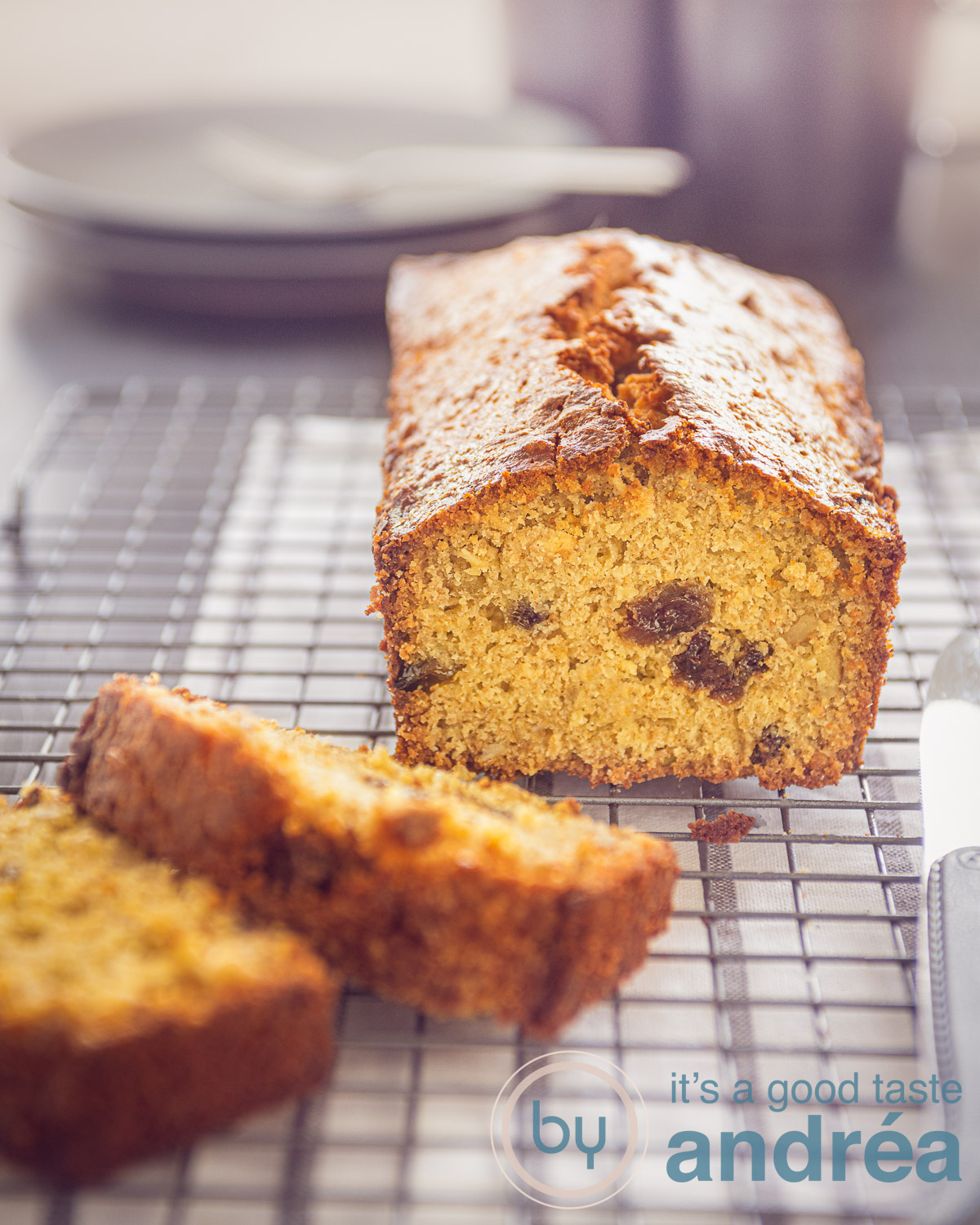 Granola cake with currant and walnuts on a rack. Two slices off. In the gray background plates and mugs.