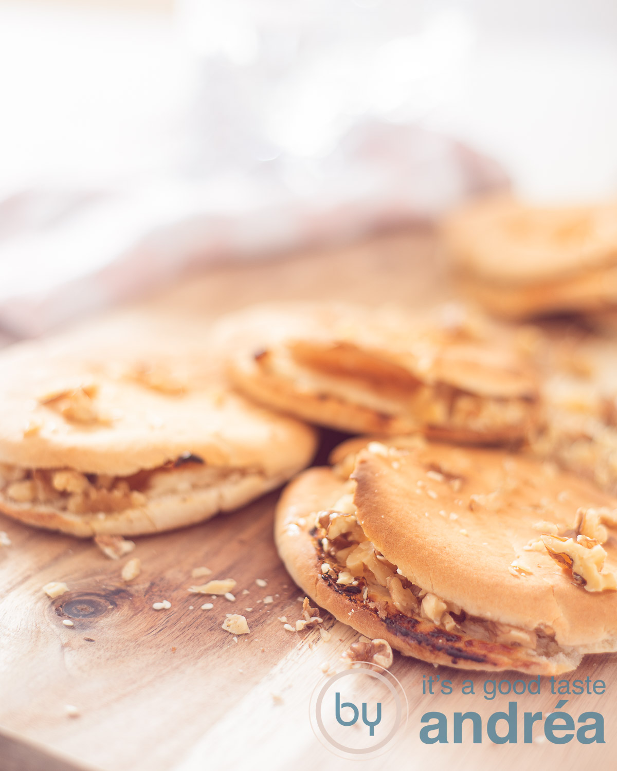 Pita bread with goat cheese and walnut dip on a wooden board. A pink white cloth in the background