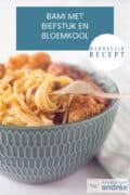 Een groene schaal met bami, bloemkool, erwtjes en biefstuk. Een tekst bovenin Bami met biefstuk en bloemkool, makkelijk recept.