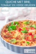 Een deel van een quiche vorm gevuld met quichedeeg, Brie, tomaten en verse kruiden.