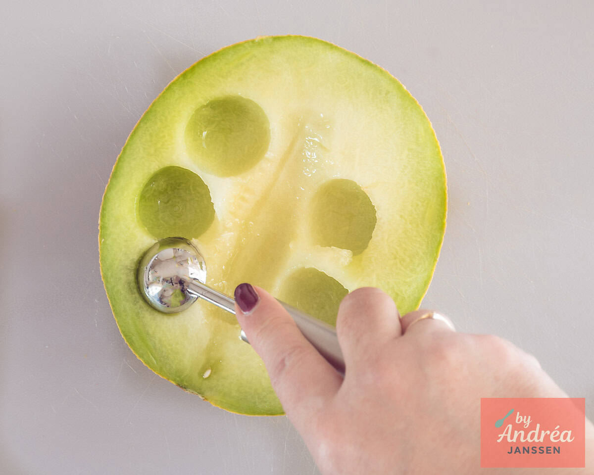 A melon scoop scoops a ball from a Galia melon