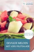 Een deel van een uitgeholde meloen gevuld met vers fruit. een tekst overlay: gevulde meloen met verse fruitsalade, makkelijk recept.