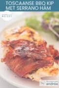 Kipfilet gewikkeld in Serranoham met Italiaanse kruiden op een wit bord. Een tekst: makkelijk recept, toscaanse BBQ kip met serranoham