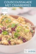 Een kom met couscous salade met cranberries, pijnboompitten en citroen, tekst: makkelijk recept, couscoussalade met cranberries