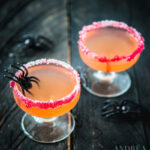 Twee Halloween cosmopolitan cocktails achter elkaar met spinnen op de tafel