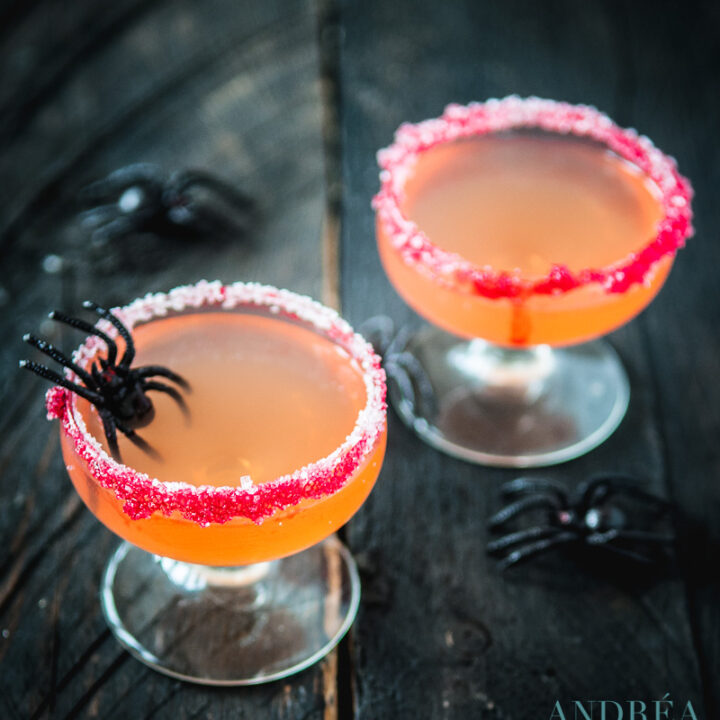Twee Halloween cosmopolitan cocktails achter elkaar met spinnen op de tafel