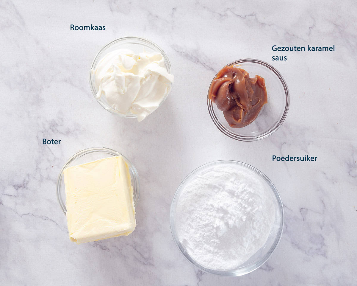 Ingrediënten Salted Karamel frosting op een wit marmeren ondergrond met salted karamel topping en frosting