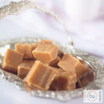 Een vierkante foto met een zilveren schaaltje met karamel fudge