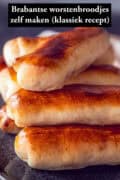 Een schaal vol Brabantse worstenbroodjes. Een tekst bovenin: Brabantse worstenbroodjes zelf maken (klassiek recept)